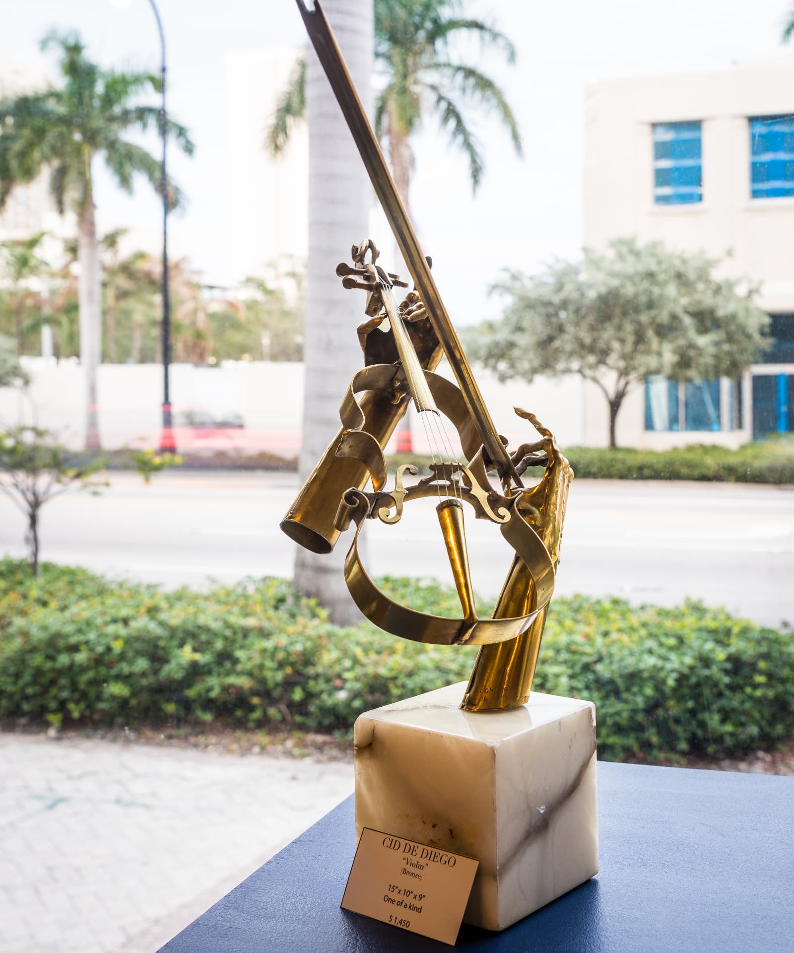 Bronze violin sculpture on a marble plinth, titled Violin by Cid de Diego