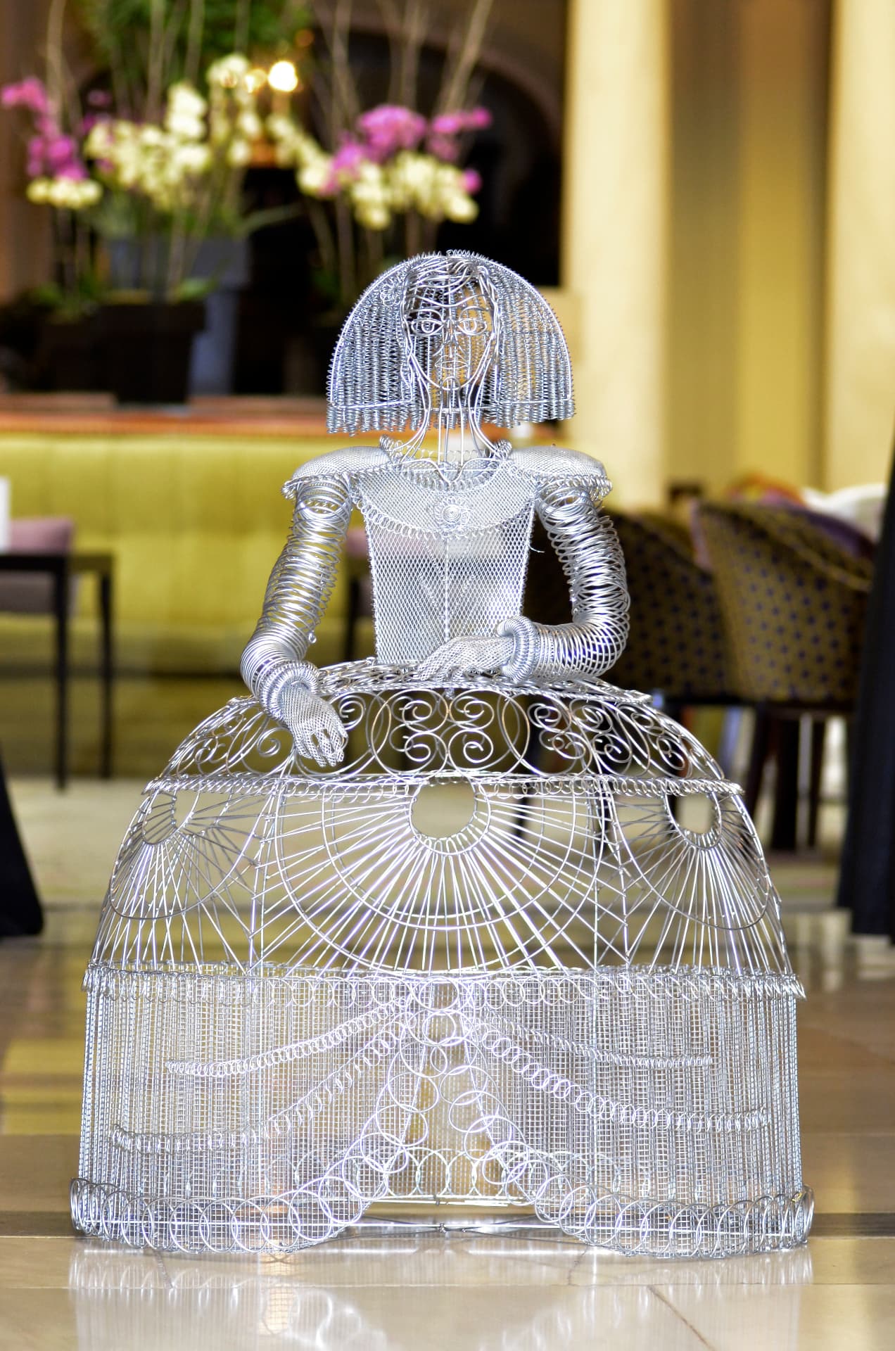 Silver wire Menina sculpture of a baroque infanta in a grand hotel lobby