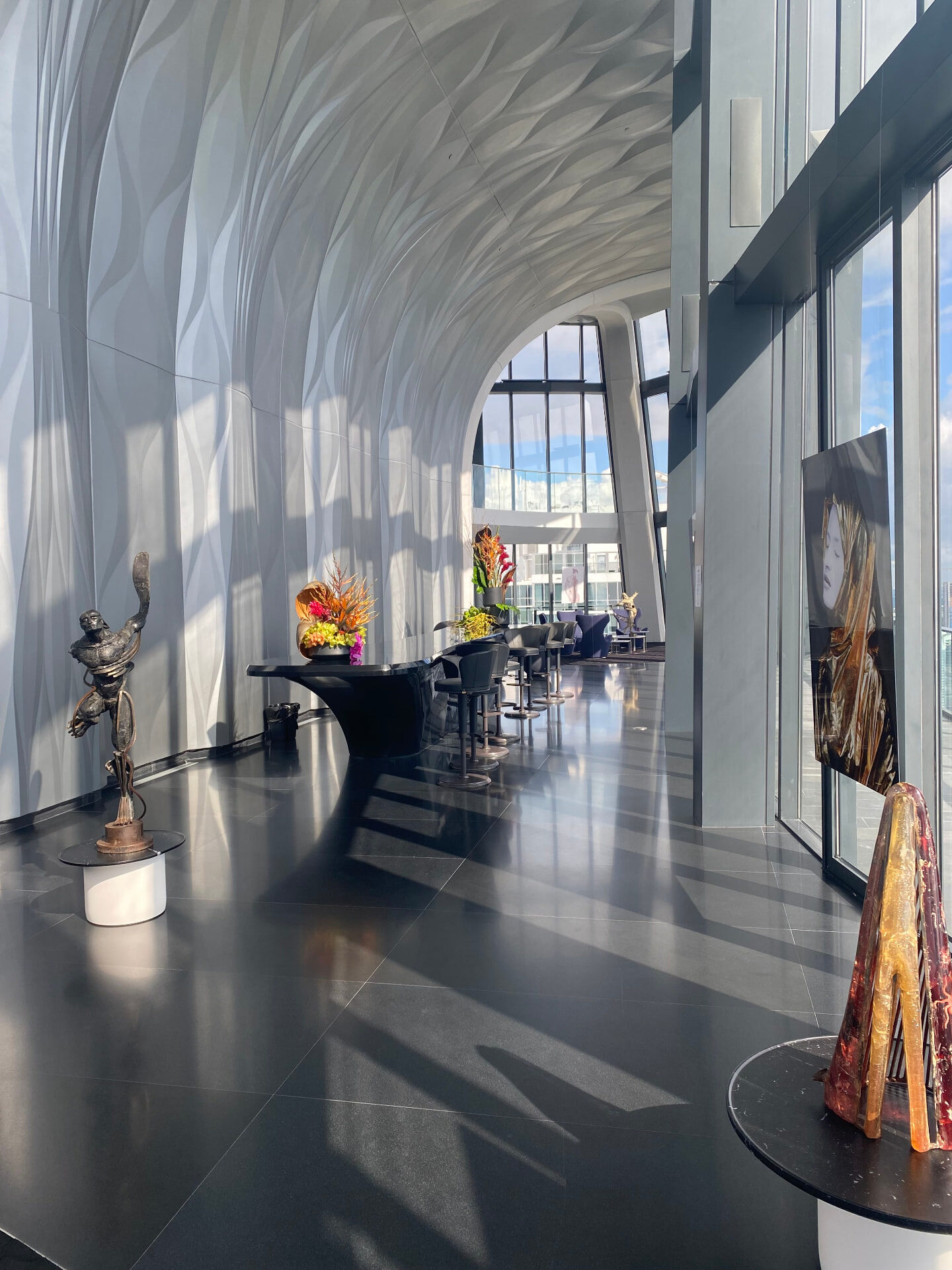 Sculpted corridor with bronze sculpture and floral arrangements at 1000 Museum, Miami